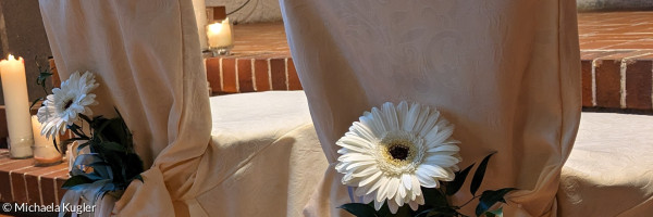 Zwei Stühle in der Kirche, für eine Hochzeit mit Blume und Husse geschmückt